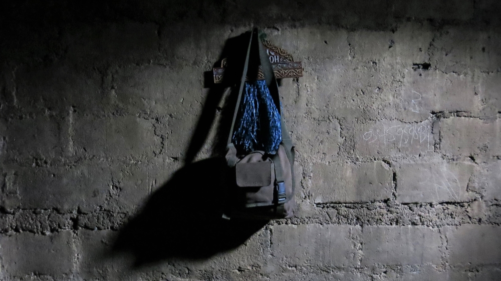 Afzal Kohistani's travel bag hangs on a peg in the room he shared with several others in their house in Allai [Asad Hashim/Al Jazeera]