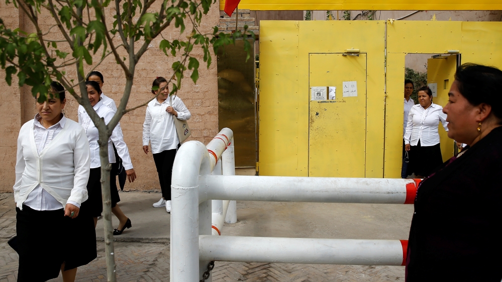 Ethnic Uighur women leave a centre where political education lessons are held in Kashgar
