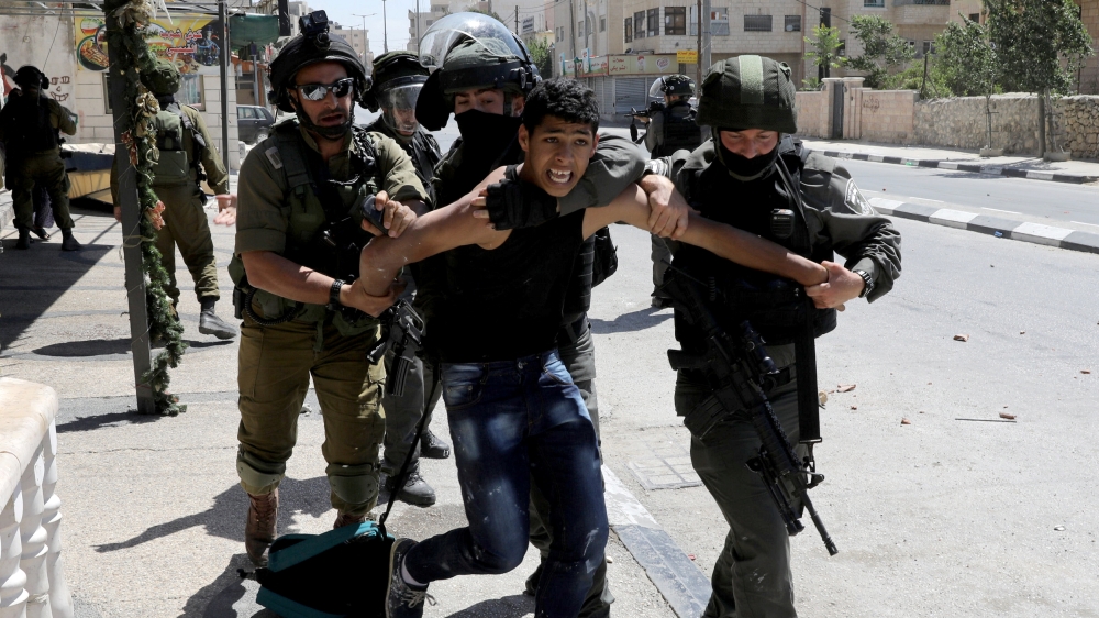 Israeli soldiers and border police detain a Palestinian during clashes in the West Bank town of Bethlehem