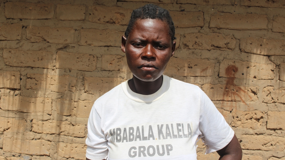 Irene Bwalya sits outside her house in Mbalala island. Her first-born daughter was pregnant when she was 14 and then again at 16 [Osman Mohamed Osman/Al Jazeera]