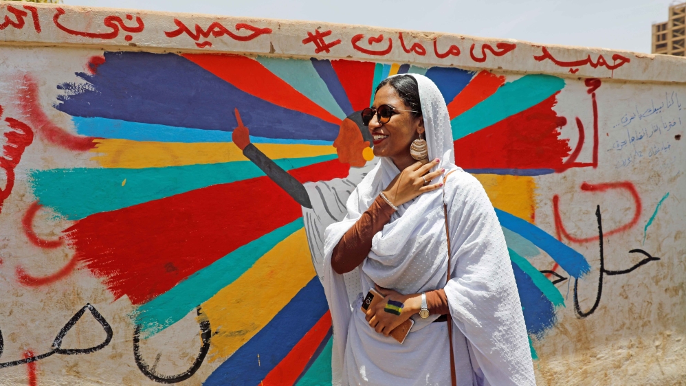 Alaa Salah stands in front of a mural depicting her in Khartoum, on April 20, 2019 [Reuters/Umit Bektas]