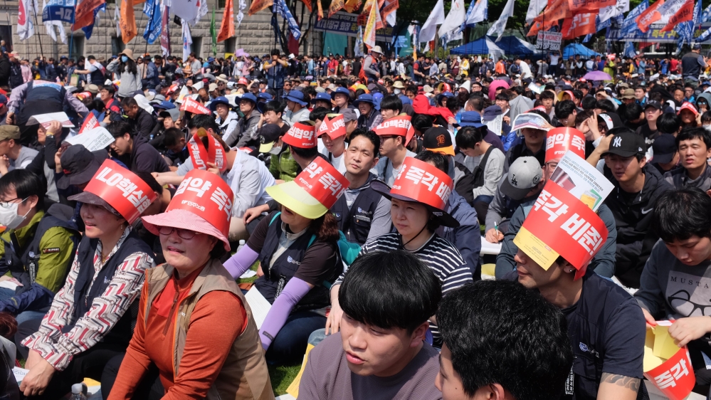 Protesters wore banner hats reading: 'Ratify the ILO's core conventions' [Sookyoung Lee/Al Jazeera]