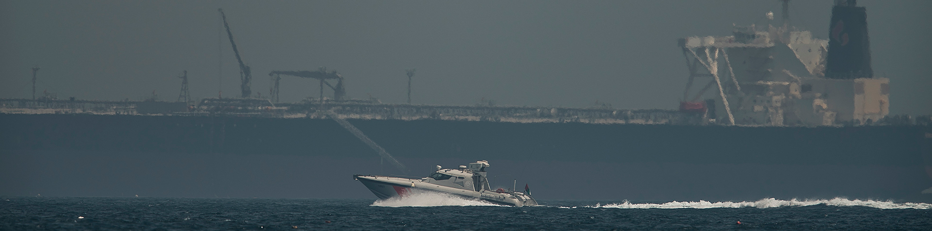An Emirati coast guard vessel passes an oil tanker off the coast of Fujairah, United Arab Emirates, Monday, May 13, 2019. Saudi Arabia said Monday two of its oil tankers were sabotaged off the coast o