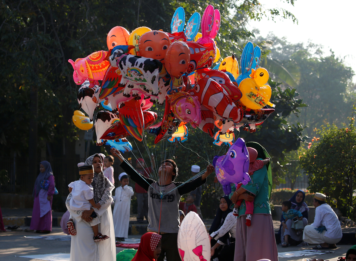Indonesian Muslims shop for balloons after attending morning prayers to celebrate Eid al-Fitr, marking the end of the holy fasting month of Ramadan, at Sunda Kelapa port in Jakarta, Indonesia, June 5,