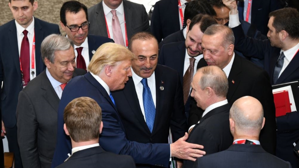 U.S. President Donald Trump talks with Russian President Vladimir Putin during the closing session of G20 leaders summit in Osaka