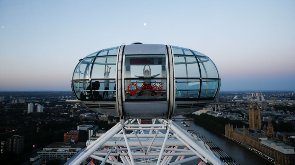 People take part in a yoga class as the sun rises during the Summer Solstice, from atop the London Eye, in London