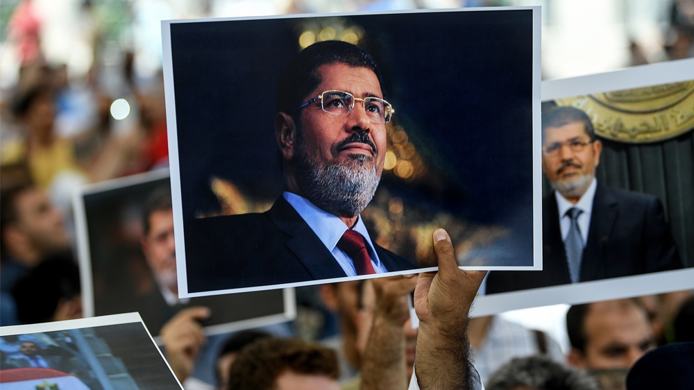People hold picture of Egyptian President Mohamed Morsi during a symbolic funeral cerenomy on June 18, 2019 at Fatih mosque in Istanbul. Thousands joined in prayer in Istanbul on Tuesday