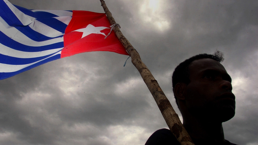 A Papuan holds the Morning Star independence flag during the funeral for prominent independence leader Theys Eluay who died in 2001. Those who fly the flag risk a prison term of as long as 15 years