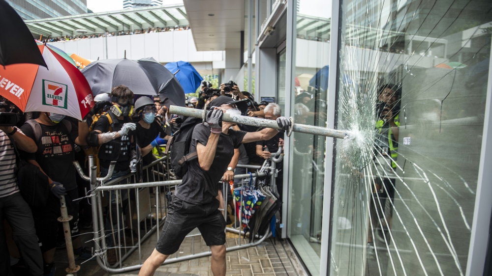 A protester is seen holding a steel pipe trying to break the glass outside Legco in Hong Kong, China. 1 July 2019. Hundreds of protesters gather outside trying to break the glass of Hong Kong''s mini-
