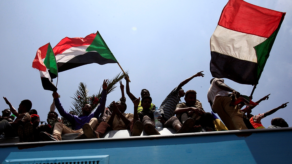 Sudanese civilians wave their national flags as they ride on the train to join in the celebrations of the signing of the Sudan''s power sharing deal, that paves the way for a transitional government, a