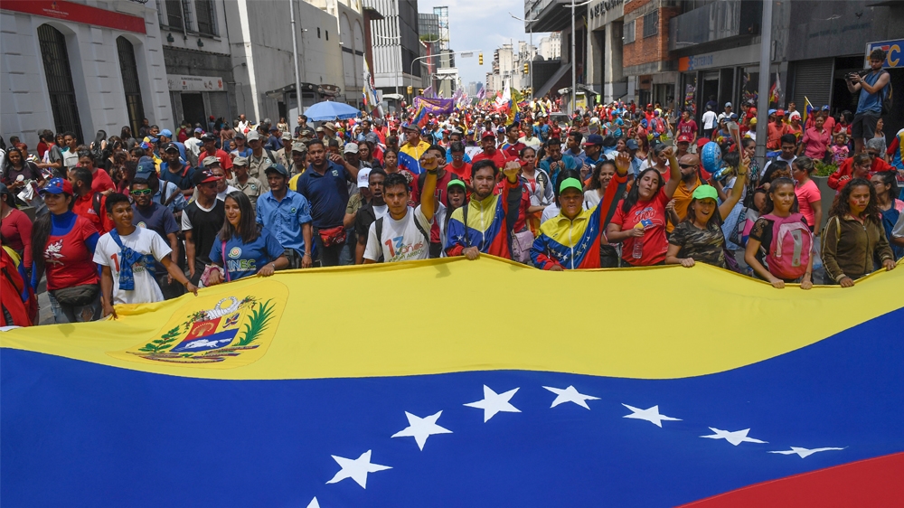 Pro-government protesters rally against US sanctions with a Venezuelan national flag in Caracas on August 7, 2019.