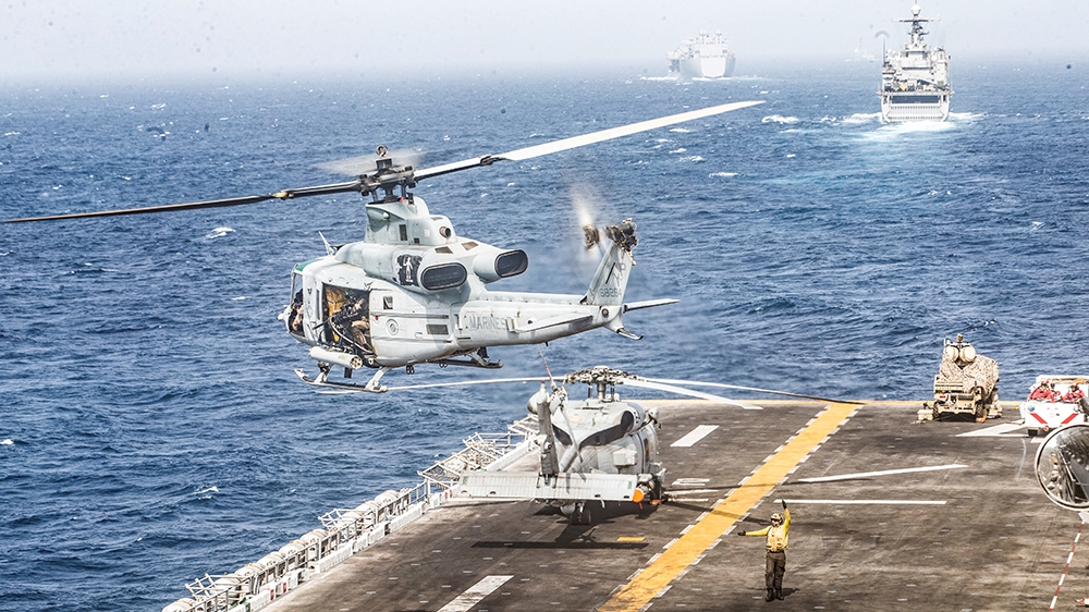 .S. Marines UH-1Y Venom helicopter takes off from the flight deck of the U.S. Navy amphibious assault ship USS Boxer, near a Light Marine Air Defense Integrated System (LMADIS) counter-unmanned aircra