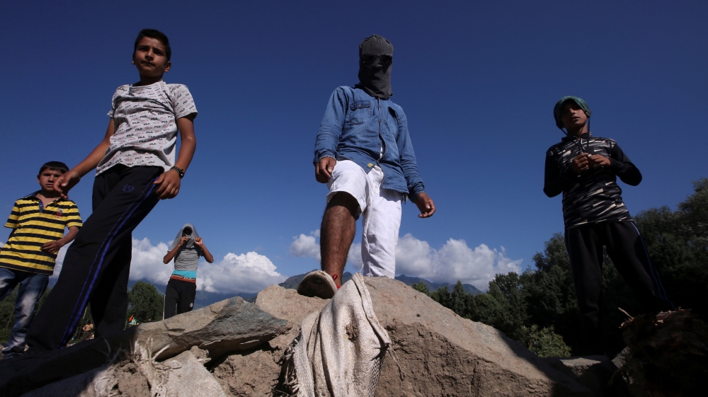 Kashmiri protesters stand at a barricade to block the entrance of a neighbourhood, during restrictions after the scrapping of the special constitutional status for Kashmir by the government