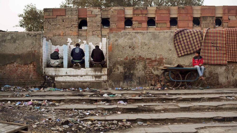 Indian squatters use a public toilet after waking up at Park No. 2 near Jama Masjid in New Delhi, India, Wednesday, Feb. 22, 2012. For thousands of people struggling at the bottom of India''s working