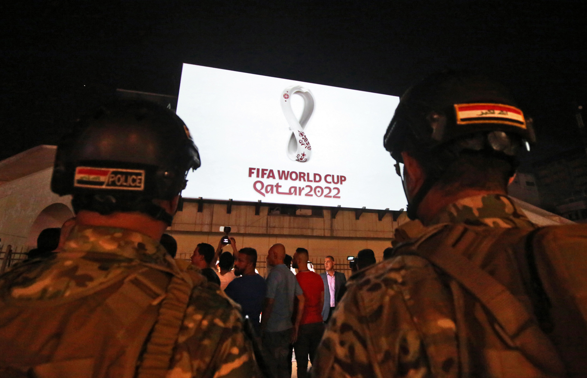 Iraqis gather at Baghdad''s Tahir square as the official logo of the FIFA World Cup Qatar 2022 is projected on the front of a building on September 3, 2019. - Qatar unveiled the logo for the 2022 World