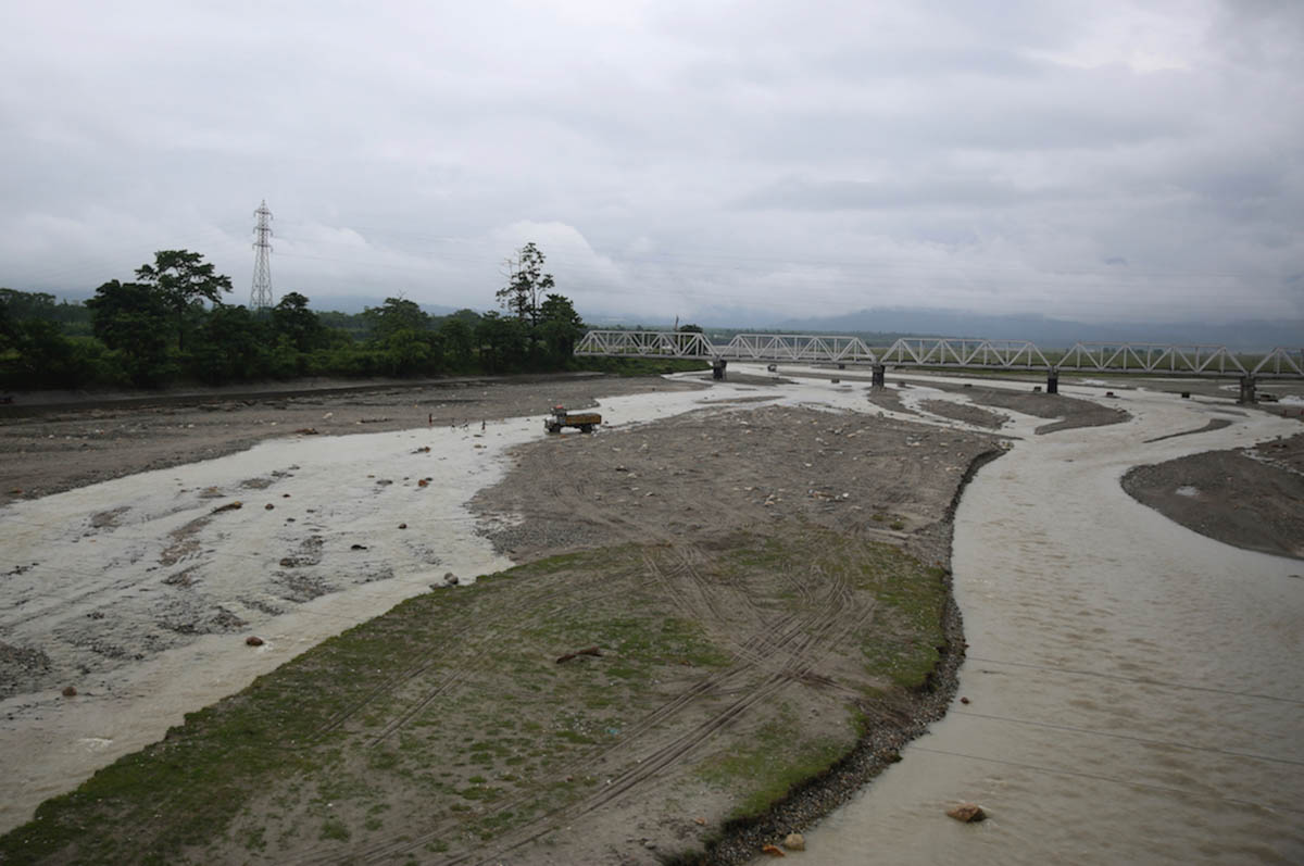 A truck carrying stones from quarries crosses a river in the Dooars region. Stone crushing has become an alternate work option for many farmers of the shut tea gardens. Despite low payments and slaver