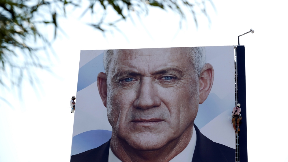 Labourers hang an election campaign banner depicting Benny Gantz, the leader of Blue and White party, in Tel Aviv, Israel September 9, 2019.