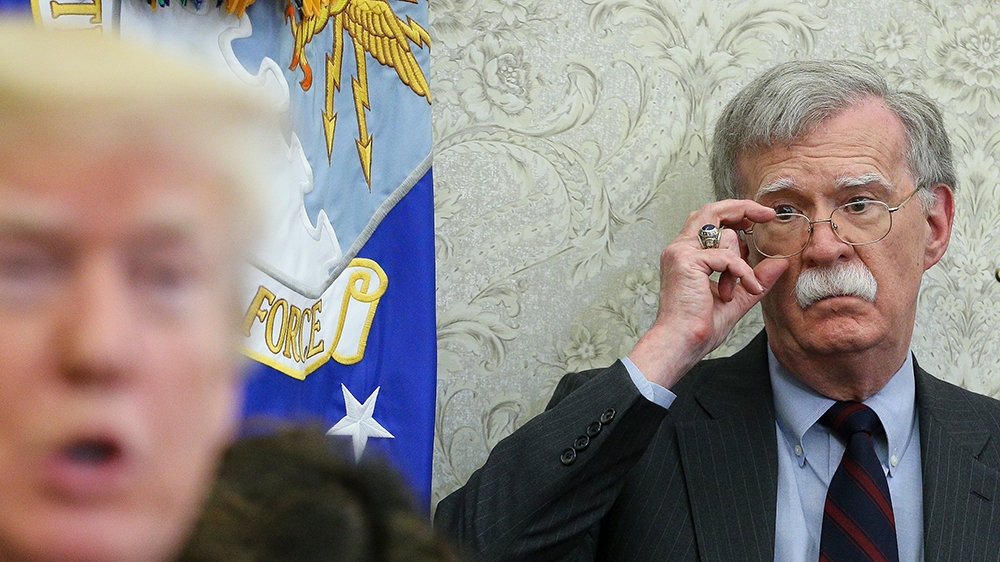 President Donald  J. Trump (L) speaks as National security advisor John Bolton (R) listens during a meeting with South Korean President Moon Jae-in, in the Oval Office of the White House in Washington