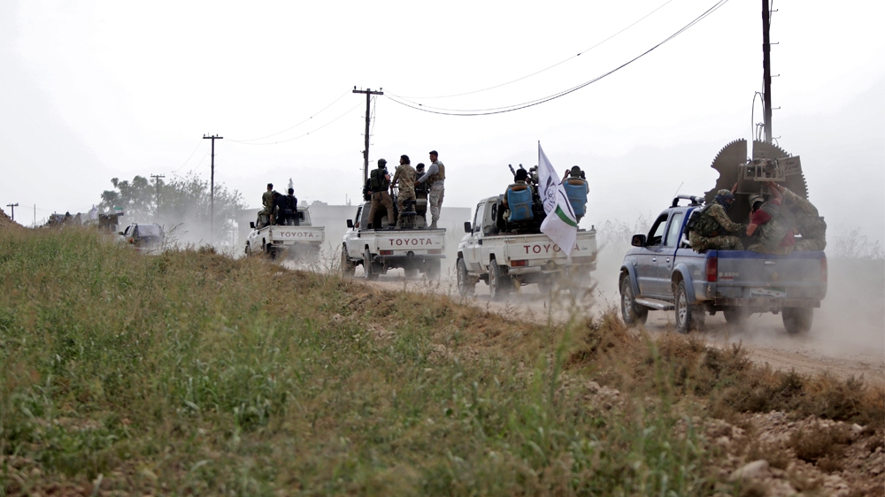 A convoy of pickup trucks transports Turkey-backed Syrian fighters on the road between the Syrian towns of Tal Abyad and Kobani on the Turkish border on October 16, 2019