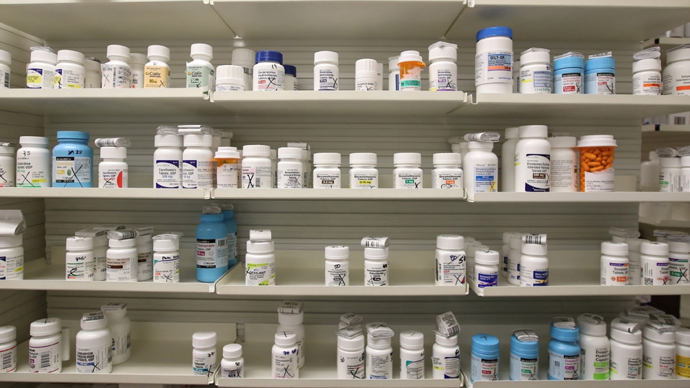 Bottles of drugs sit on shelves at a pharmacy.