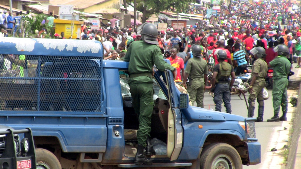 Members of security forces stand guard as people march during a protest over a suspected effort by President Alpha Conde to seek a third term in Conakry, Guinea October 24, 2019