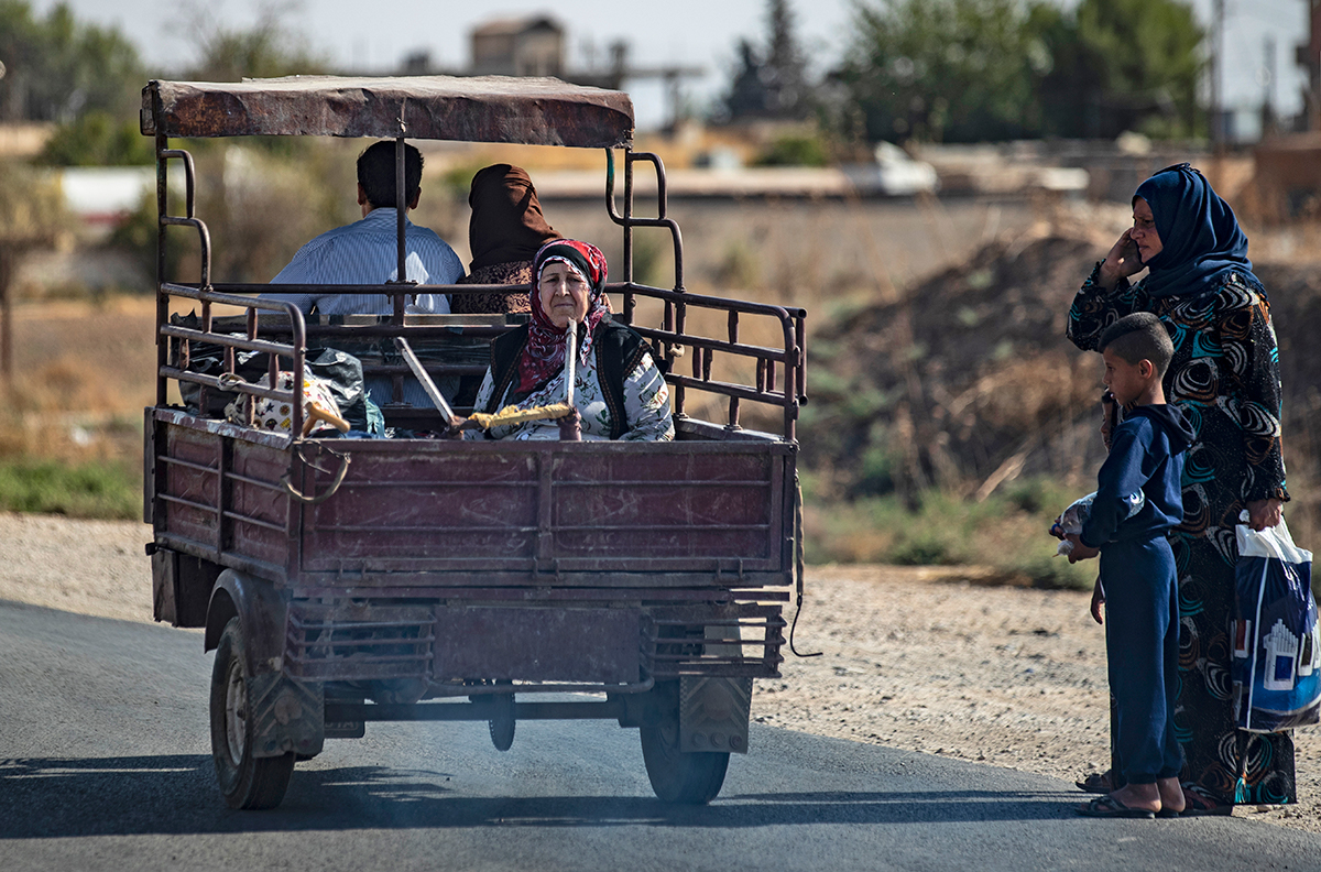 Syrian Arab and Kurdish civilians arrive to Tall Tamr town, in the Syrian northwestern Hasakeh province, after fleeing Turkish bombardment on the northeastern towns along the Turkish border on October