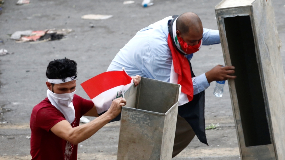 Demonstrators cover themselves during a protest over corruption, lack of jobs, and poor services, in Baghdad, Iraq October 25, 2019