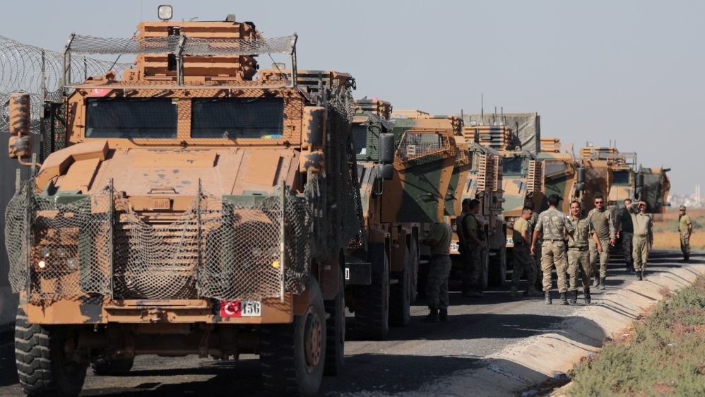 Turkish soldiers stand near military trucks in the village of Yabisa, near the Turkish-Syrian border, Syria, October 12, 2019