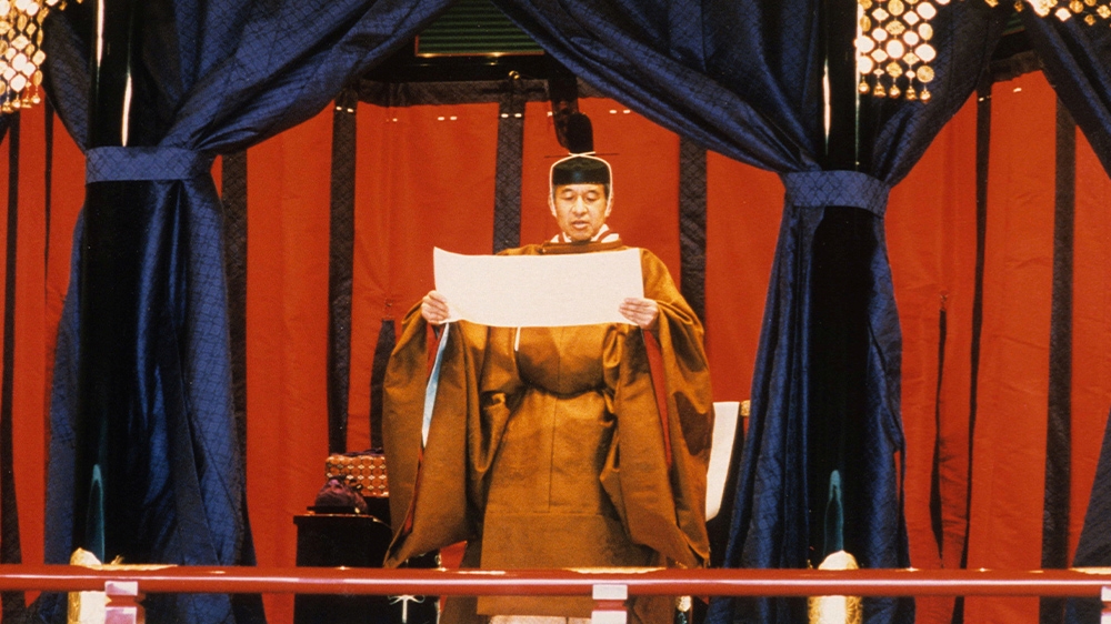 Emperor Akihito pledges to observe the Constitution of Japan during the ceremonies to mark his accession to the Chrysanthemum Throne in 1990. Naruhito is expected to wear a traditional robe and headdress like his father. [Handout via Reuters]