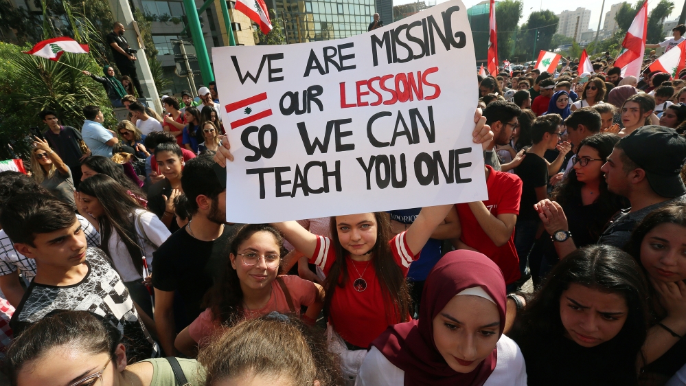 A student carries a banner during ongoing anti-government protests near the Ministry of Education and Higher Education in Beirut, Lebanon November 7, 2019. REUTERS/Aziz Taher