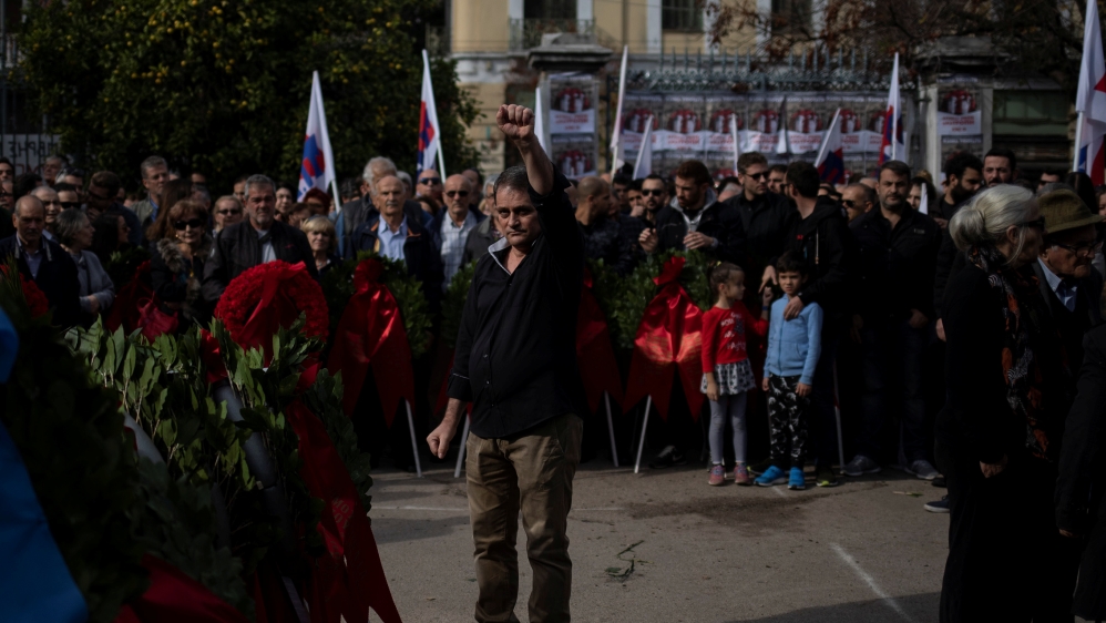 A man raises his fist after laying a wreath on a monument inside the Athens Polytechnic, to mark the 46th anniversary of a 1973 student uprising against the military junta