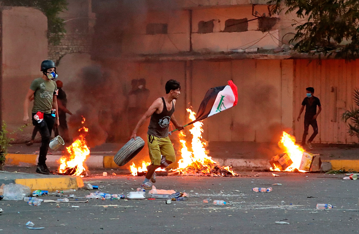 Anti-government protests set fire while security forces fired live ammunition and tear gas near the state-run TV in Baghdad, Iraq, Monday, Nov. 4, 2019. (AP Photo/Khalid Mohammed)