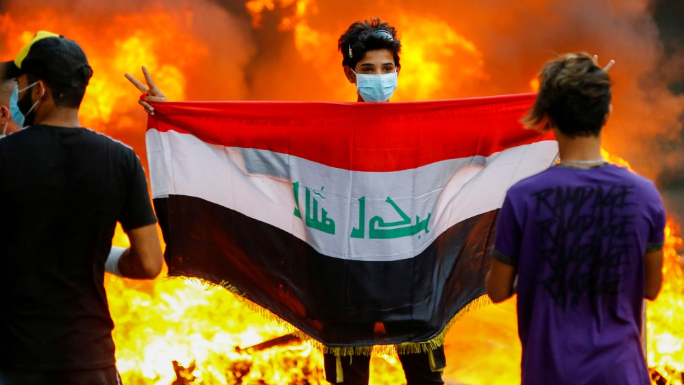 A demonstrator carries an Iraqi flag during ongoing anti-government protests in Baghdad