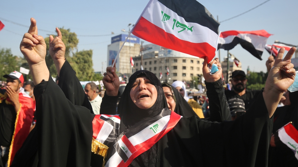 Iraqi women chant slogans and wave national flags as they take part in a protest in the capital Baghdad's Tahrir square during ongoing anti-government protests on November 4, 2019. Iraqi security forc