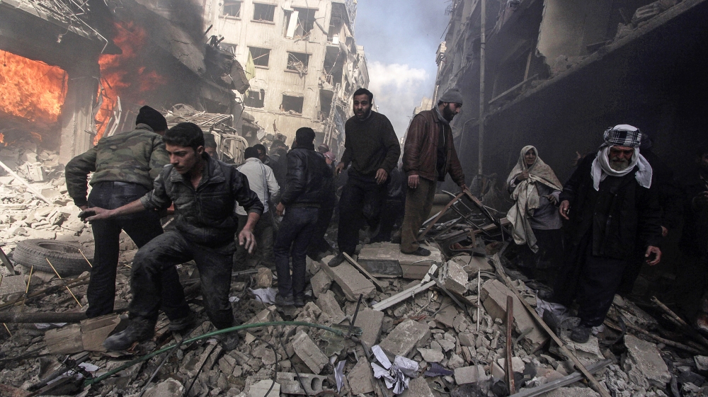 People walk on rubble as others try to put out a fire after what activists said were airstrikes followed by shelling by forces loyal to Syria''s President Bashar al-Assad in the Douma neighborhood of D