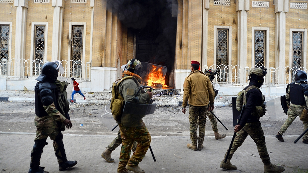 Smoke billows from the shrine dedicated to the late Iraqi Shiite Ayatollah Mohammed Baqir al-Hakim in the southern Iraqi Shiite holy city of Najaf on December 1, 2019, during anti-government demonstra