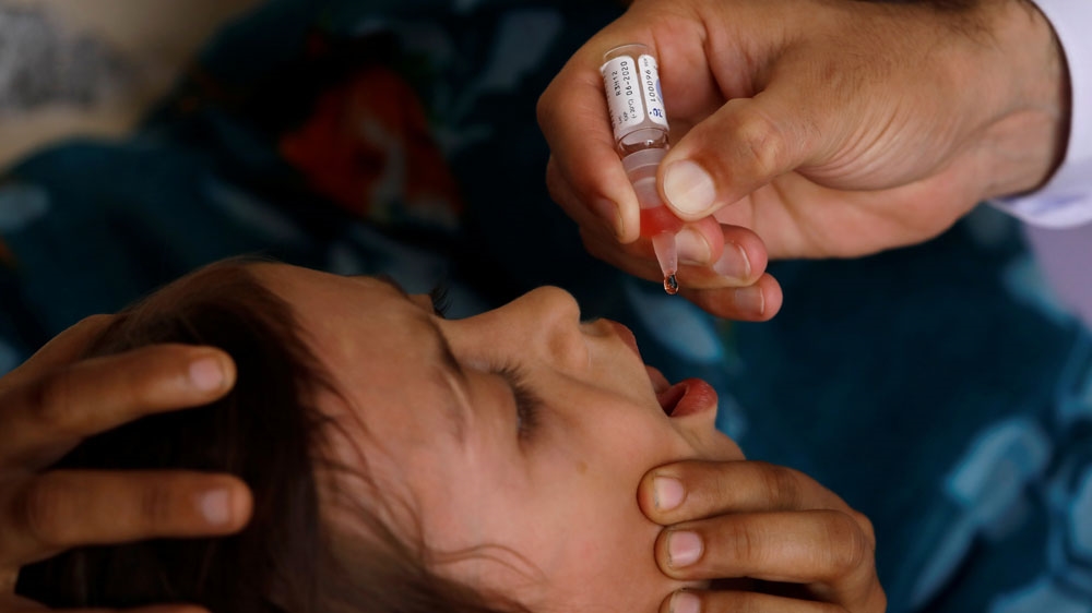 Polio vaccine drops are administered to a child at a civil dispensary in Peshawar
