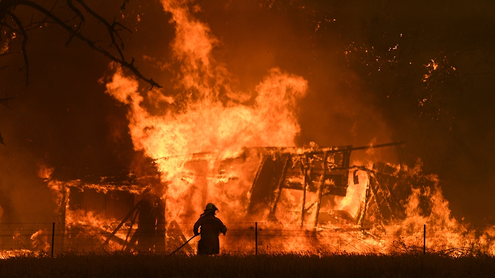 NSW Rural Fire Service crews fight the Gospers Mountain Fire as it impacts a structure at Bilpin, Saturday, December 21, 2019. Conditions are expected to worsen across much of NSW as temperatures tip