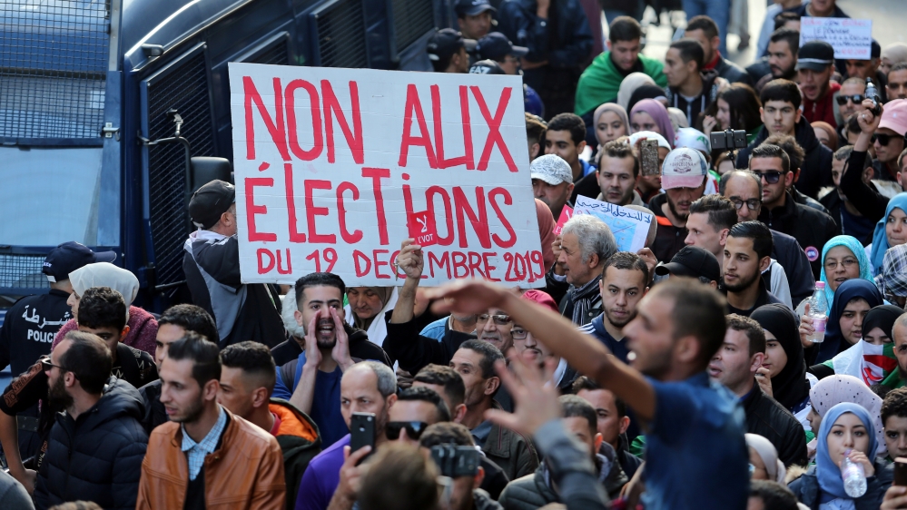 Demonstrators carry banners and gesture during a protest rejecting upcoming presidential election in Algiers