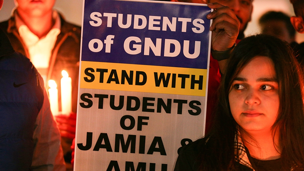 Activists of National Students' Union of India (NSUI) take part in a candle light vigil to show solidarity with Jamia Milia Islamia University and Aligarh Muslim University students and against Delhi