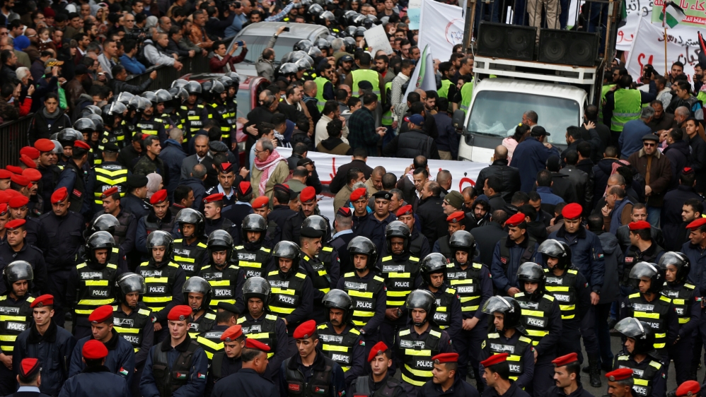 Jordanian police officers walk during a protest against a government's agreement to import natural gas from Israel, in Amman