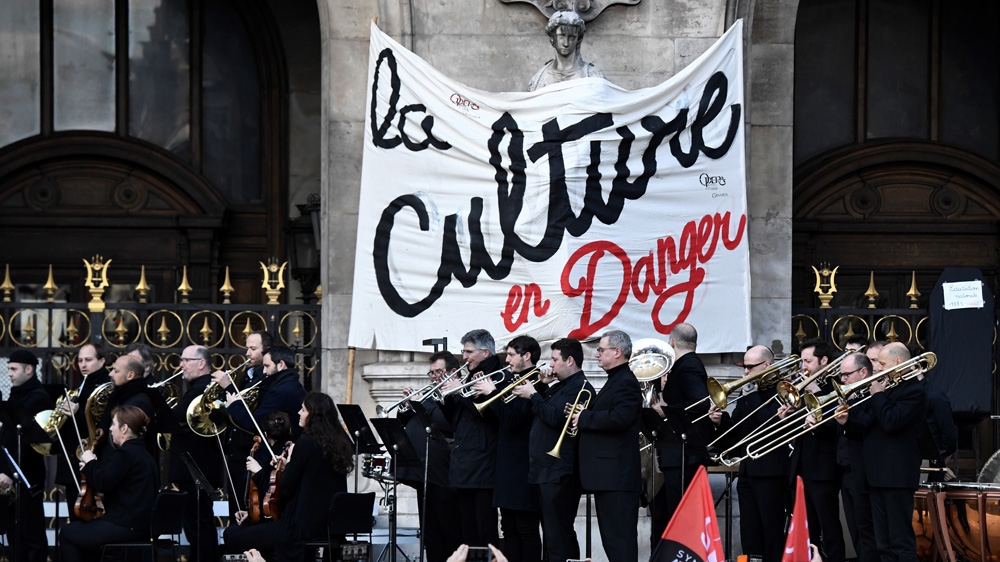 Musicians perform in front of the Palais Garnier during a demonstration of striking employees of the Opera Garnier and the Comedie Francaise