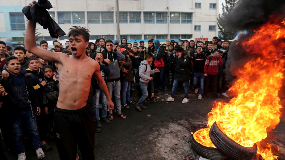 Palestinian students protest against the U.S. President Donald Trump's Middle East peace plan as tires burn, in the southern Gaza Strip