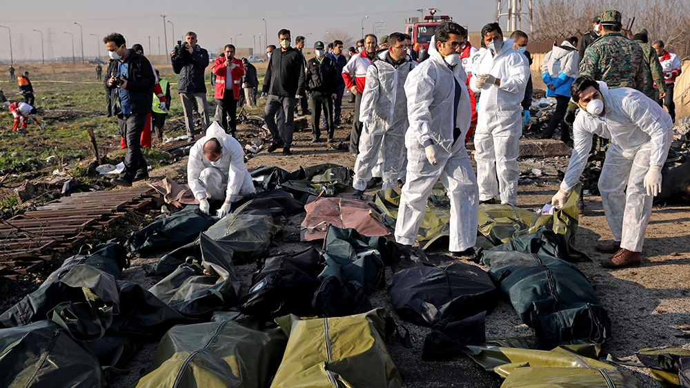 Forensic investigators work at the scene of a Ukrainian plane crash as bodies of victims are collected, in Shahedshahr, southwest of the capital Tehran, Iran, Wednesday, Jan. 8, 2020. A Ukrainian airp