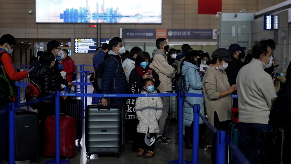 People wear protective masks while they travel on a bus in Shanghai