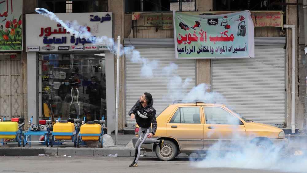 A demonstrator throws a tear gas canister back at the Iraqi security forces during ongoing anti-government protests in Baghdad, Iraq January 25, 2020. REUTERS/Thaier al-Sudani