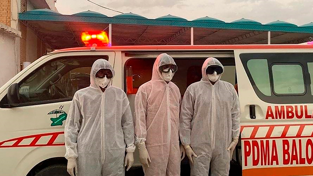 Pakistani medical staff stand at the Pakistan-Iran border, which was closed due to the outbreak of coronavirus in neighboring Iran, Tuesday, Feb. 25, 2020, in Taftan, Pakistan. Pakistan has closed its
