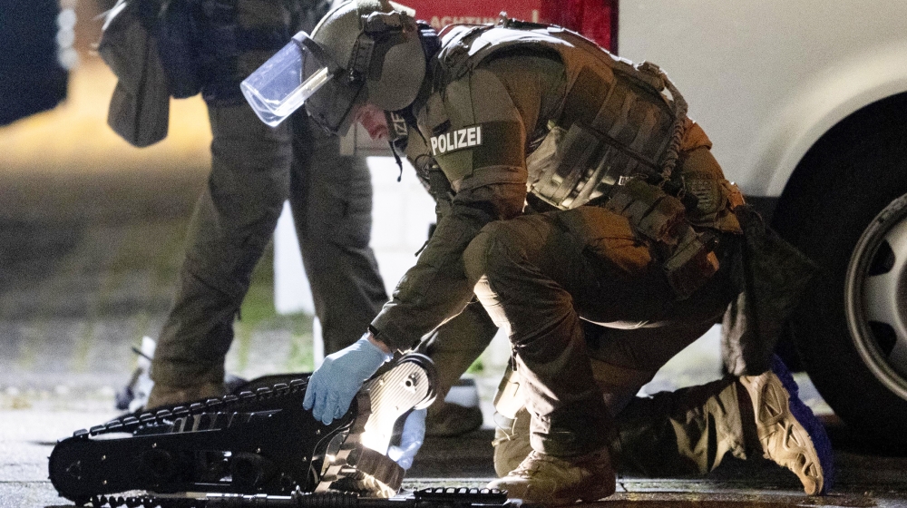 A special forces officer works on a robot in front of a house that is searched through by police in Hanau, Germany Thursday, Feb. 20, 2020. Eight people were killed in shootings in and outside two hoo