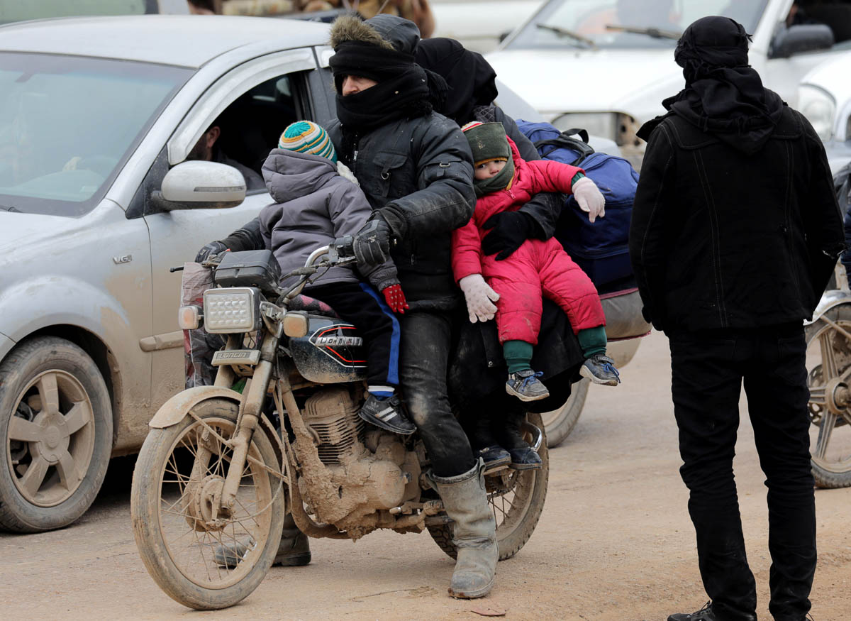 Internally displaced Syrians from western Aleppo countryside, ride on a motorbike in Hazano near Idlib, Syria, February 11, 2020. REUTERS/Khalil Ashawi