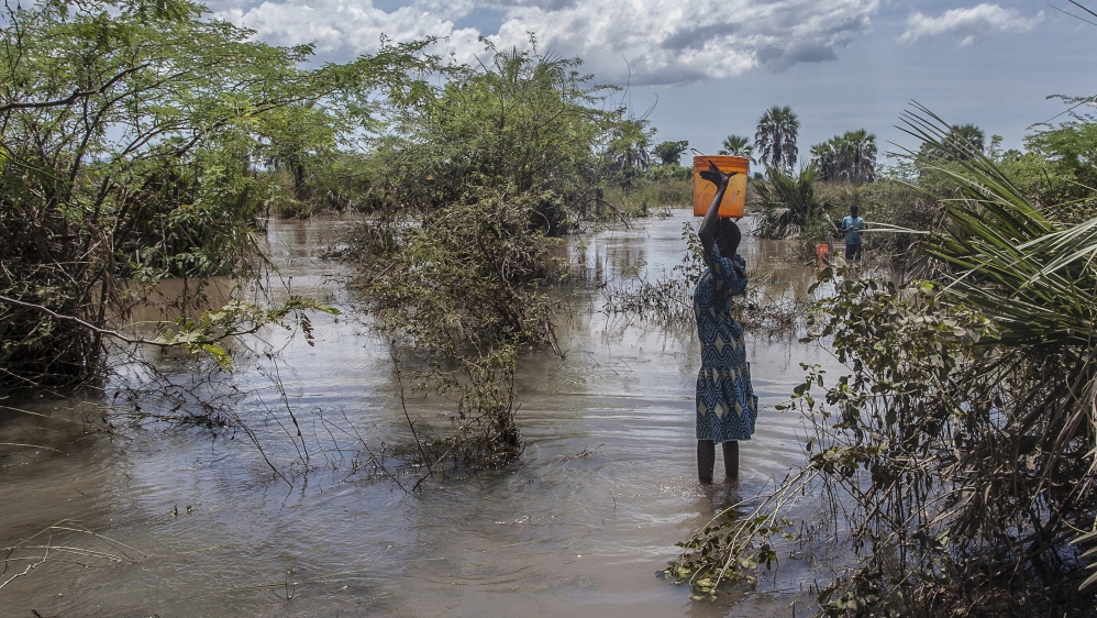 A girl fetches water from a river created by flood water near Nsusa Village Island camp for displaced people due to the floods in the Nsanje district of southern Malawi, on March 15, 2019. At least 56